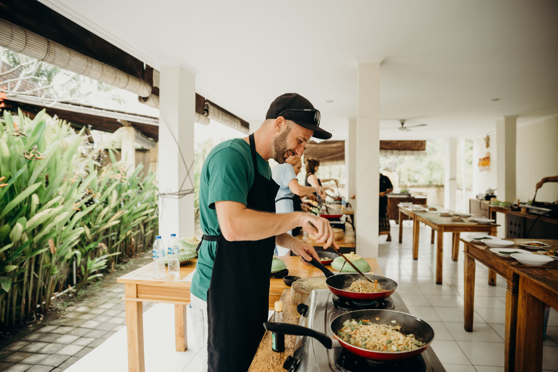 A practitioner leading a small hands-on cooking workshop outdoors