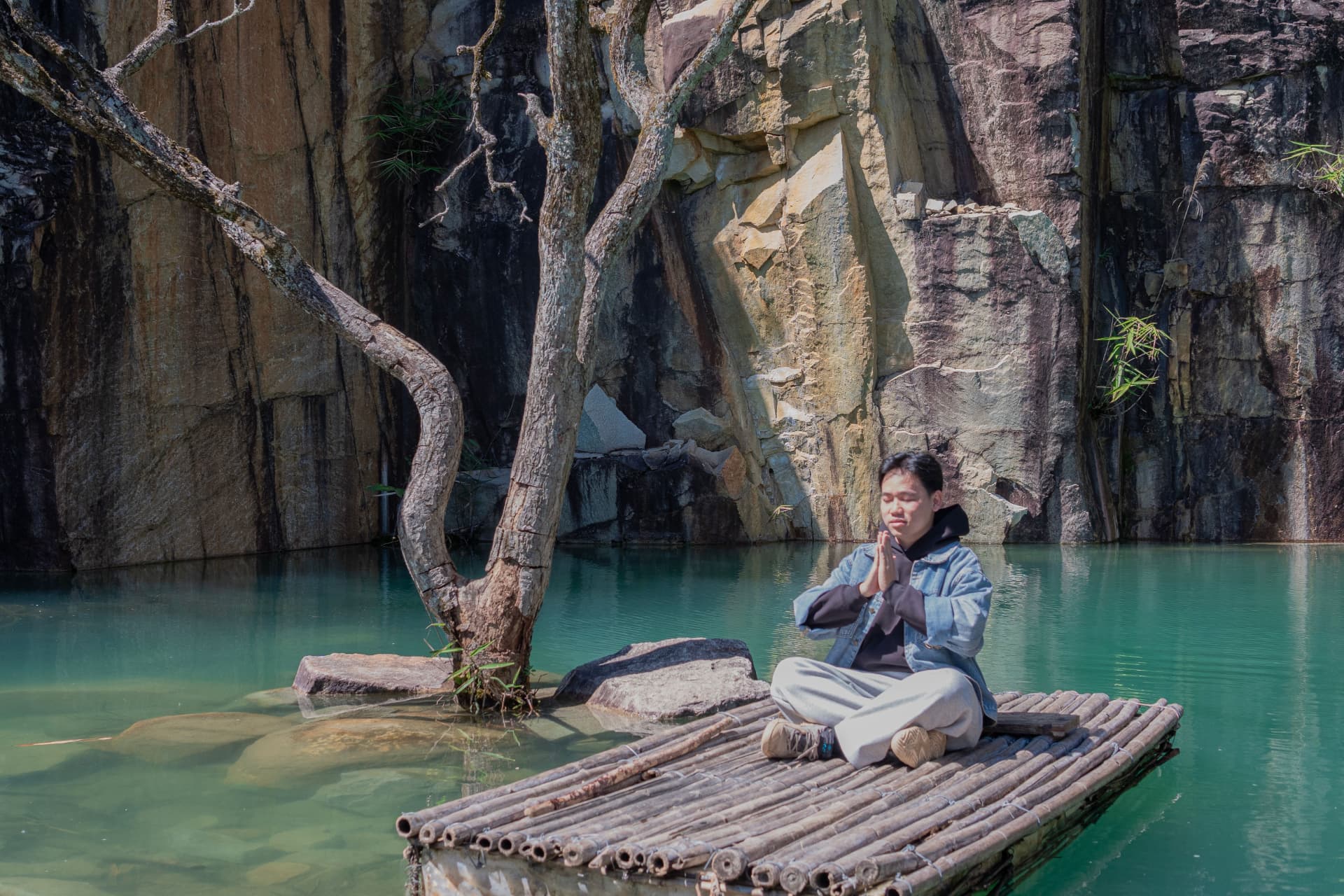 A practitioner sitting quietly beside still water